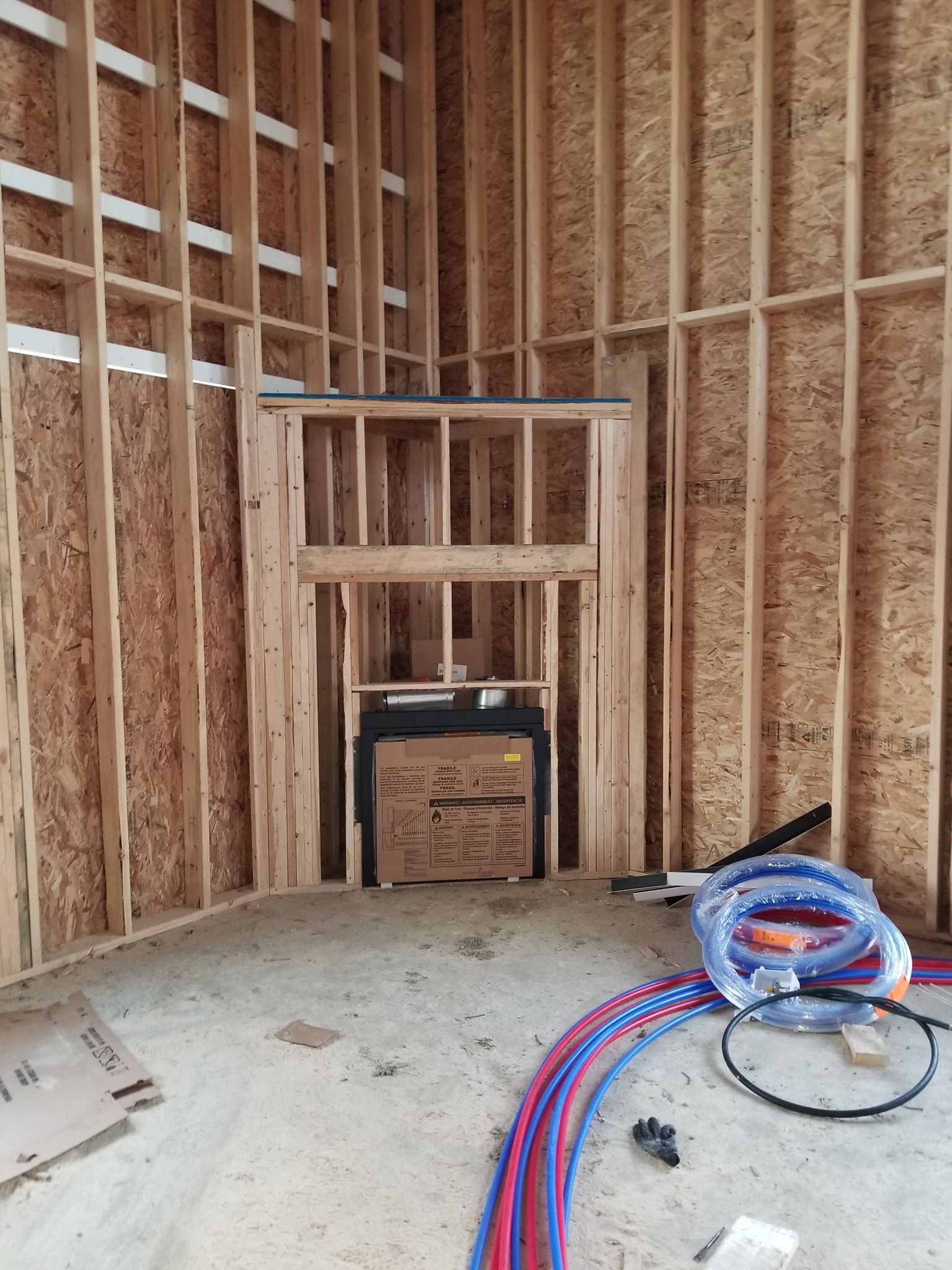 a room in a house under construction with pipes on the floor .