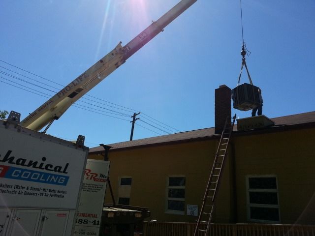 a mechanical cooling truck is being lifted by a crane
