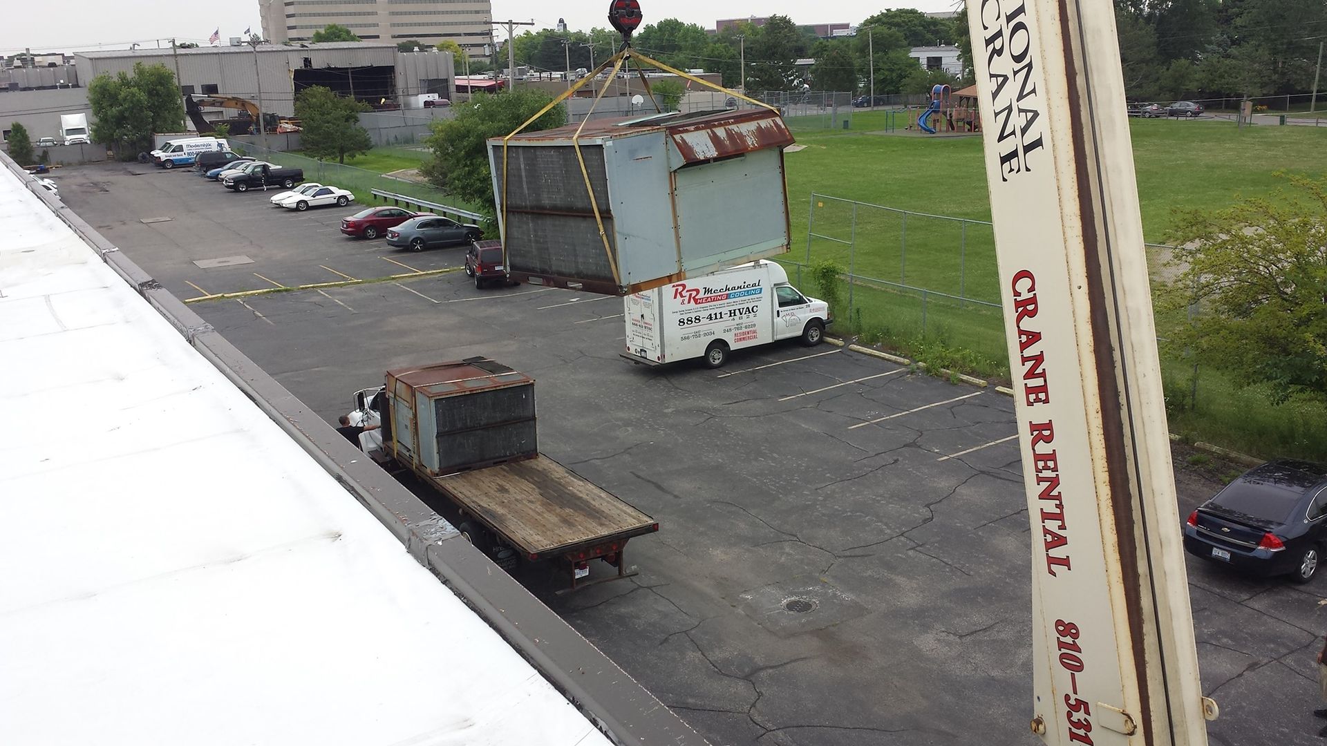 a crane is lifting a container in a parking lot