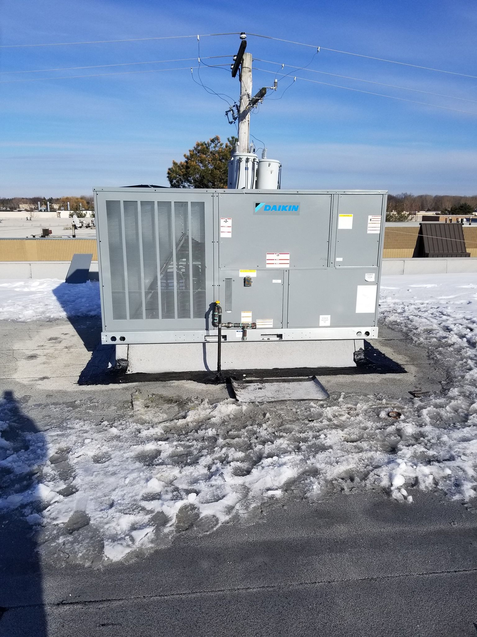 a large air conditioner is sitting on top of a snow covered roof .