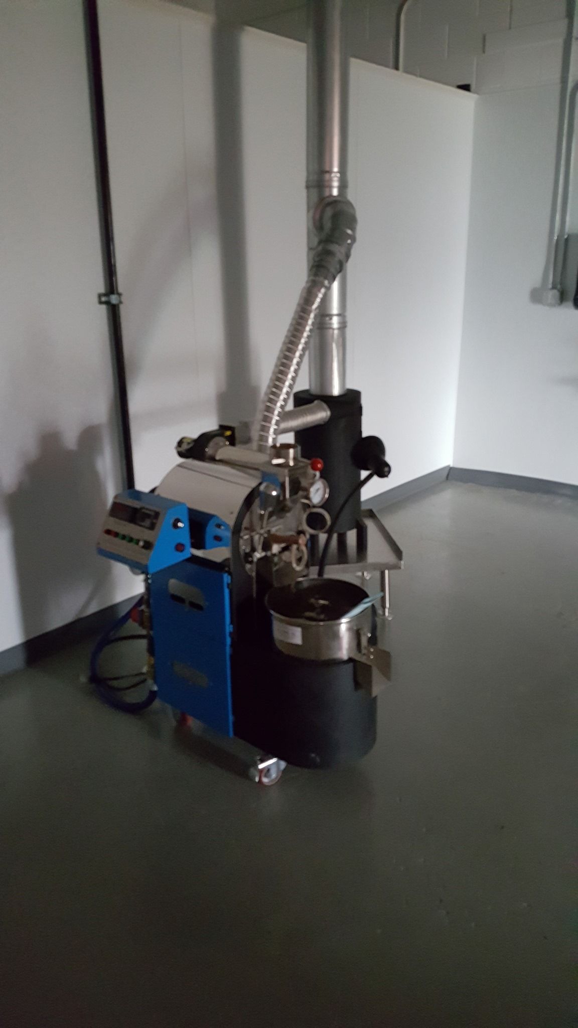 a machine is sitting on the floor in a room next to a wall .