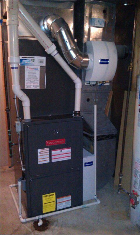 an air conditioner is sitting in a basement next to a water heater