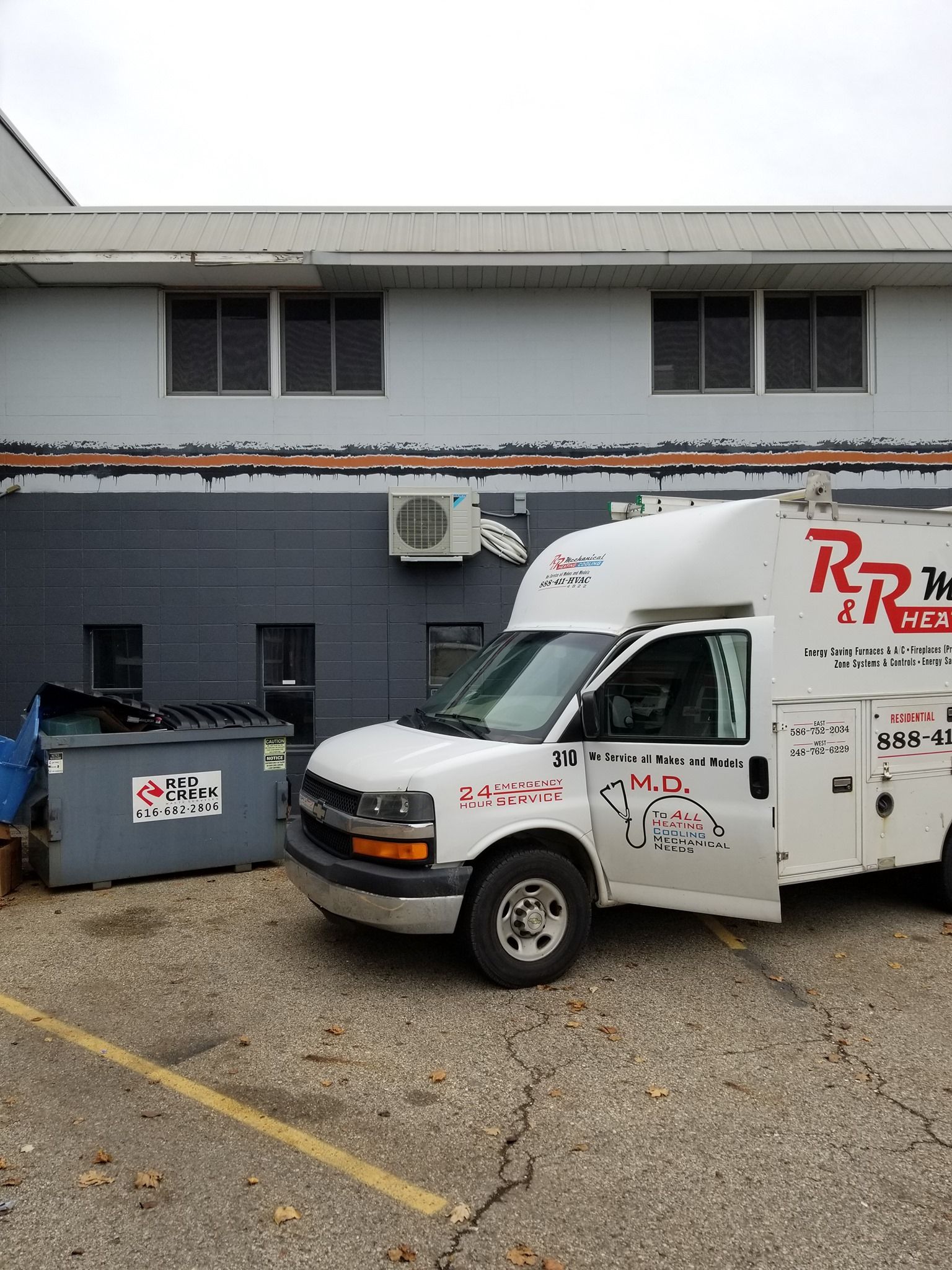 a white van is parked in front of a building .
