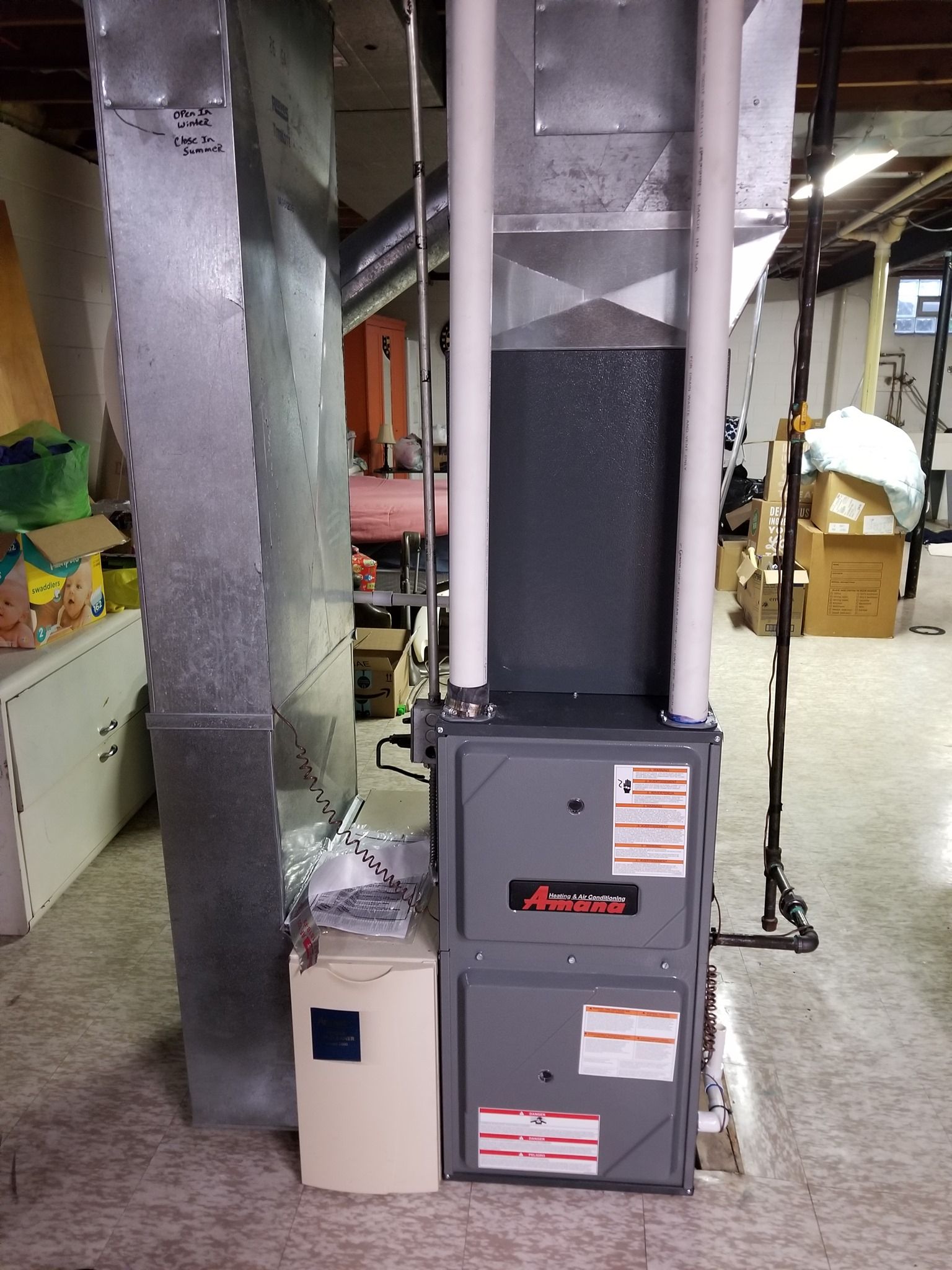 an air conditioner is sitting in a basement next to a wall .