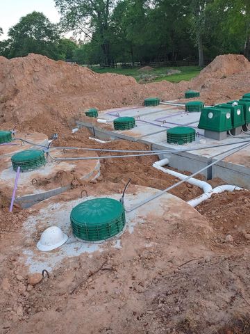 A septic system is being built in the dirt.
