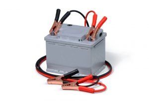 A car battery with jumper cables attached to it