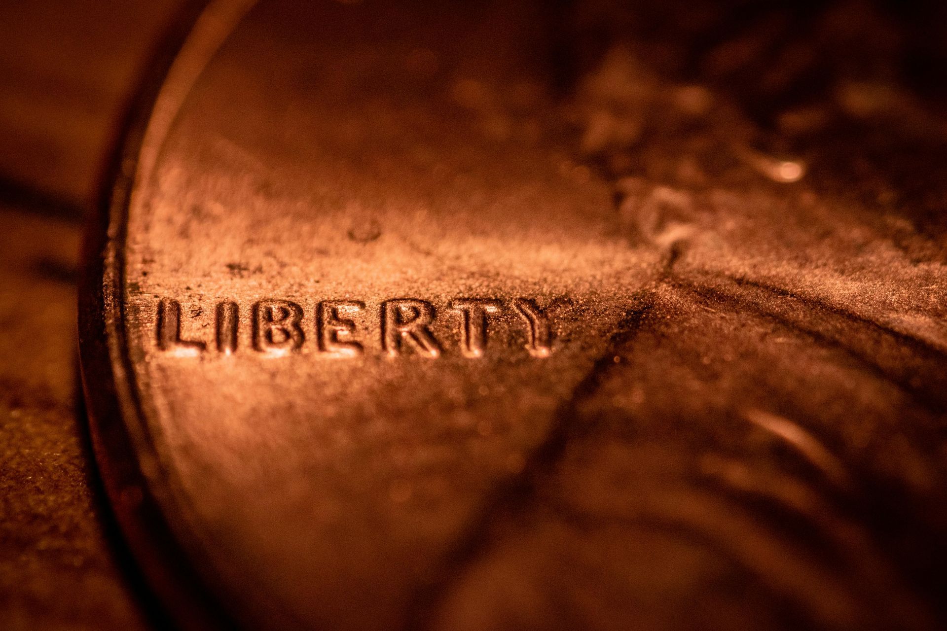 Close-up of a copper penny showing the word “LIBERTY” under warm lighting