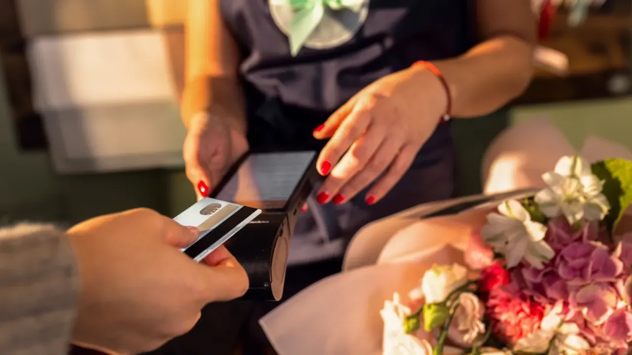 woman giving her bank card to pay for her services in a hair salon