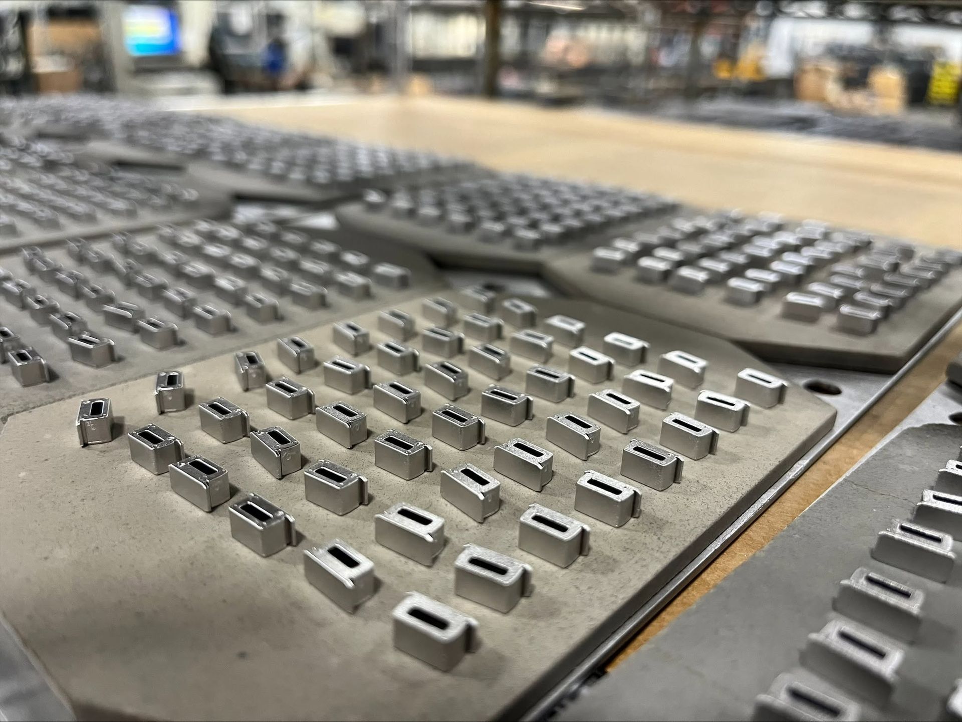 view of multiple metal printing type blocks arranged in rows on a flat surface.