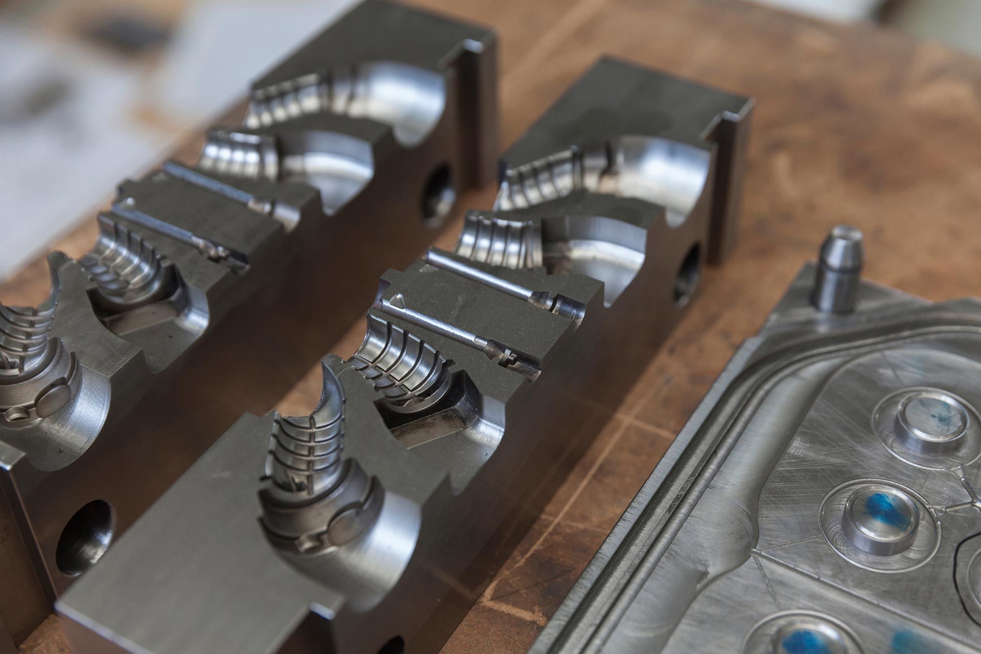 Close up of precision machined metal mold components with detailed grooves and polished surfaces. Close up of precision machined metal mold components with detailed grooves and polished surfaces.