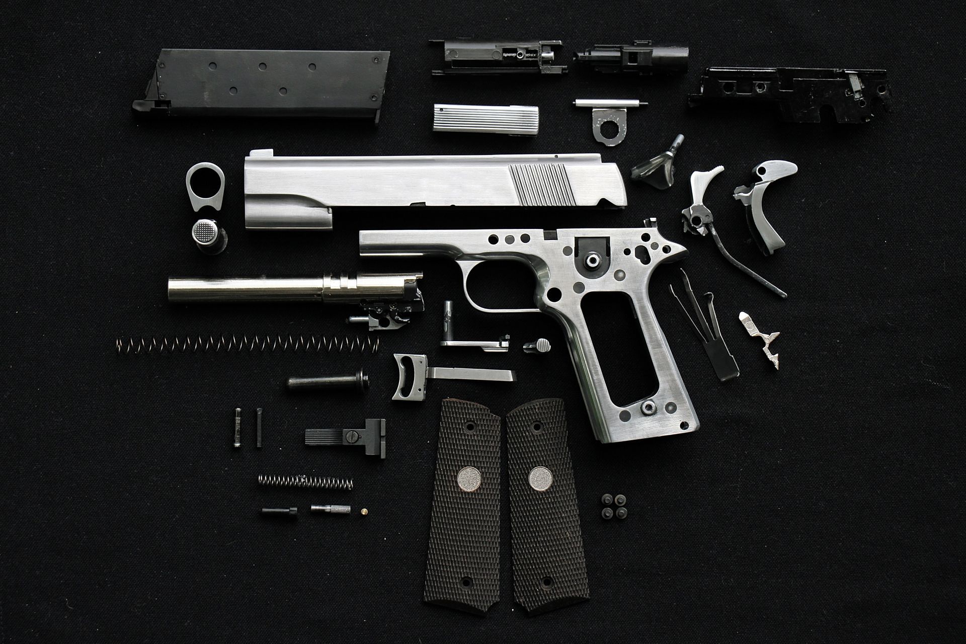 Disassembled handgun on black background. Disassembled handgun on black background.
