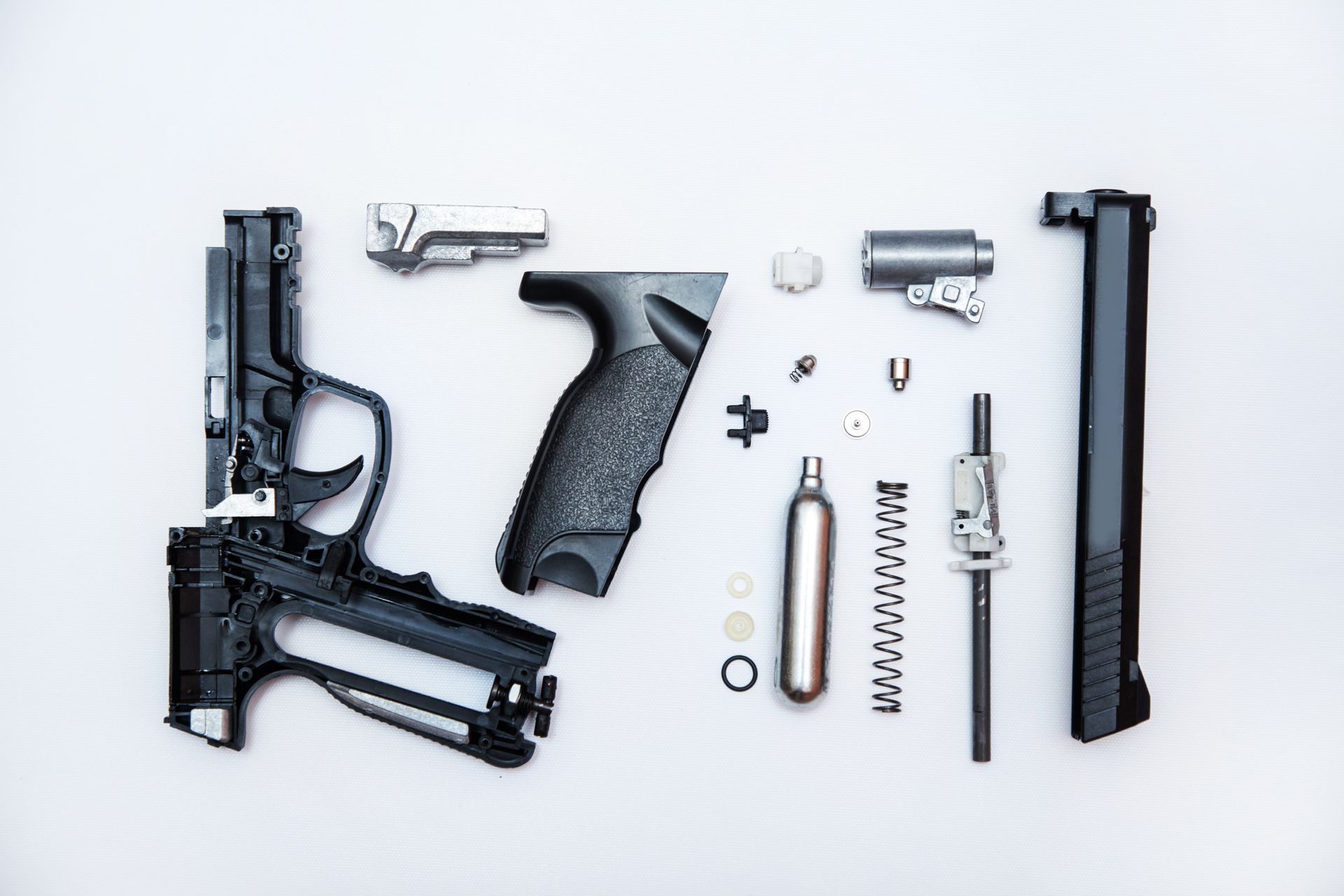 Disassembled gun parts on a white background. Disassembled gun parts on a white background.