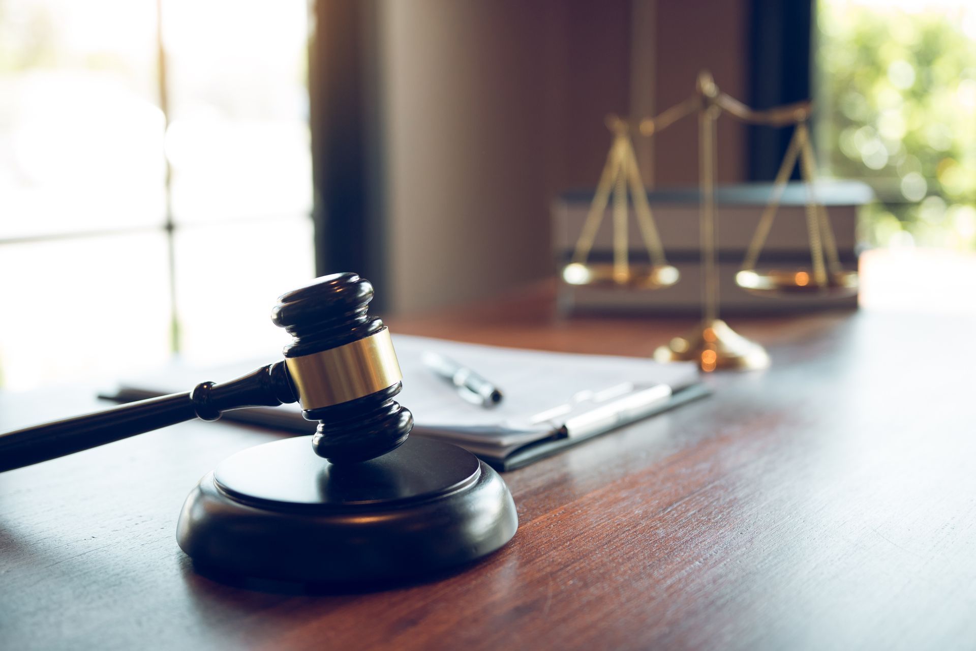 Judge’s gavel on desk with scales of justice in a courtroom setting