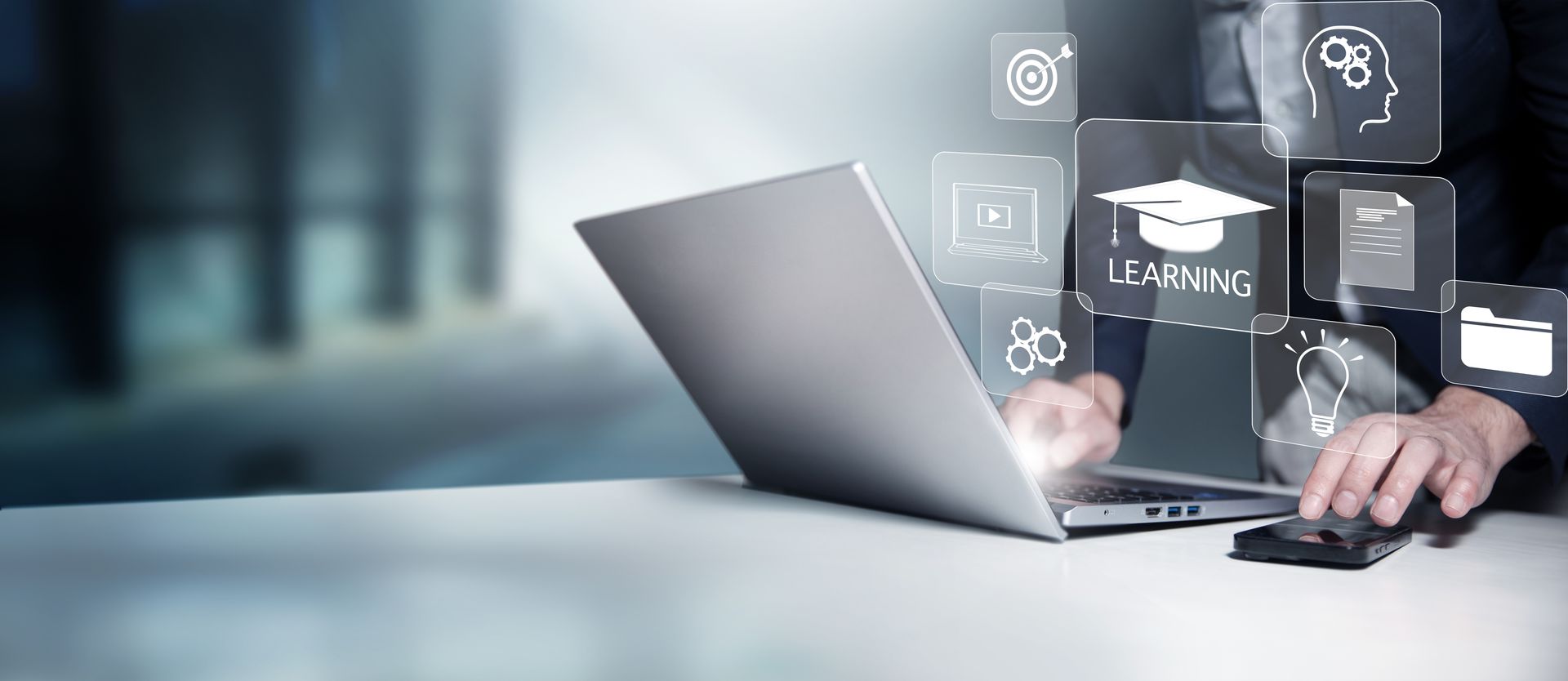 Laptop on desk with hand using a mouse and floating digital interface icons