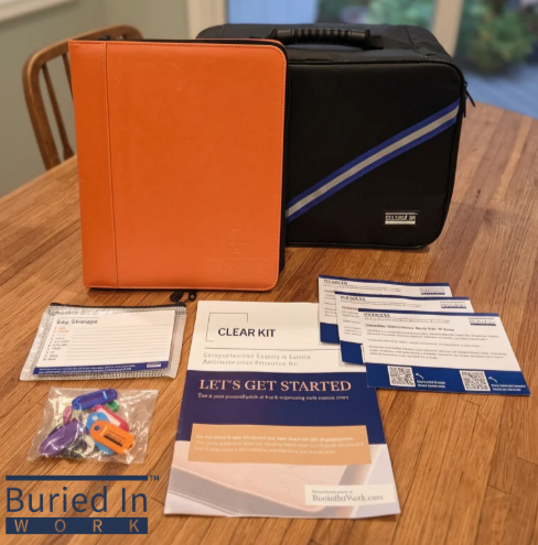 Work kit with orange and black bags, forms, clear pouch, and tools spread on a wooden table