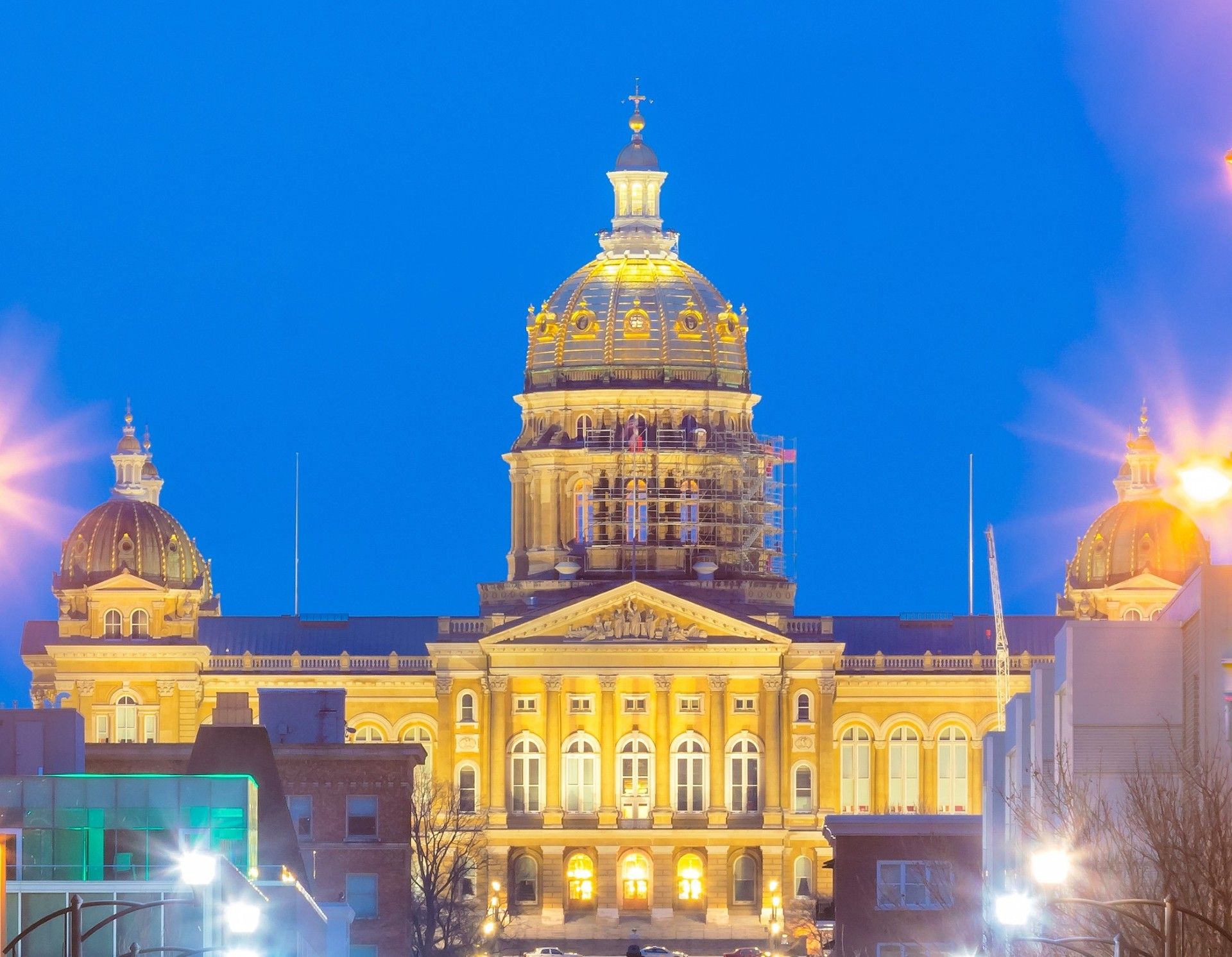 Illuminated domed government building at night against a deep blue sky