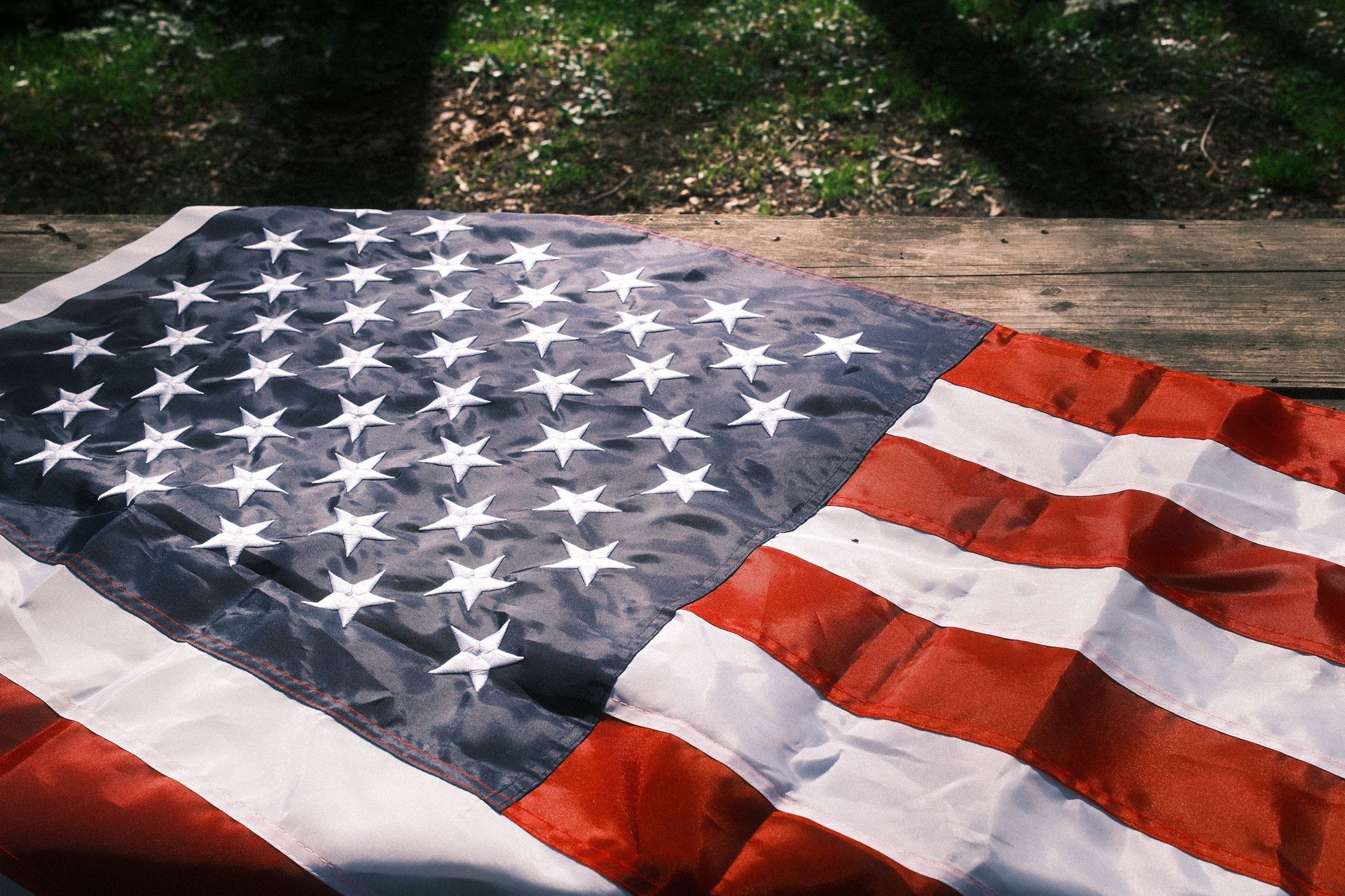 American flag lying on grass in sunlight