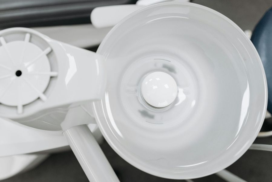 Close-up of white plastic components, including a funnel-shaped cup and circular parts, on a dark surface