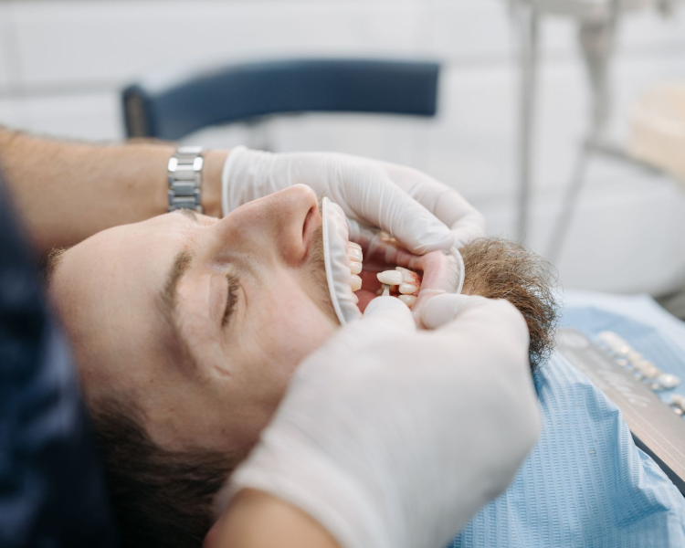 Close-up of dental implant with white crowns on pink gums