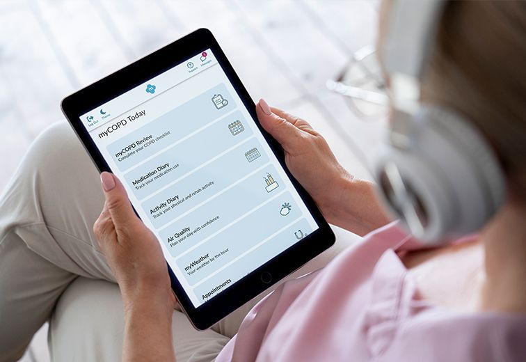 A woman wearing headphones is using a tablet computer.