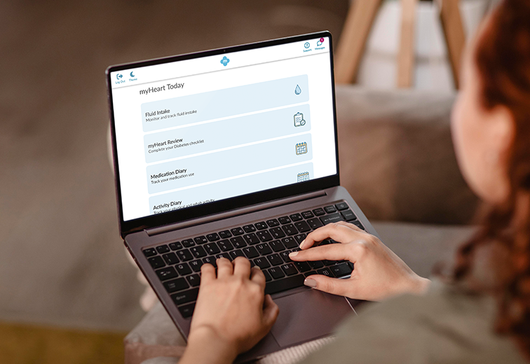 A woman is typing on a laptop computer while sitting on a couch.