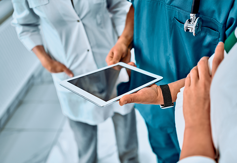 A group of doctors are looking at a tablet computer.
