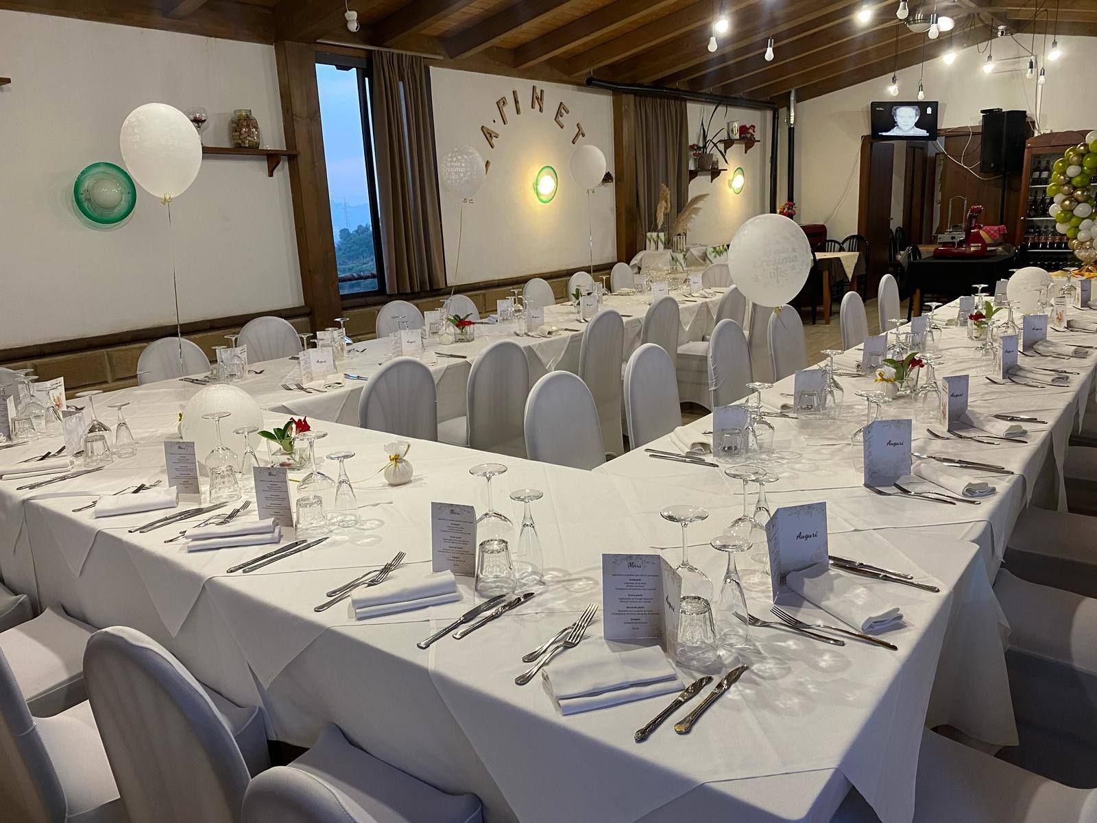 Sala da banchetto decorata con lunghi tavoli apparecchiati con tovaglie bianche, ideale per un evento formale.