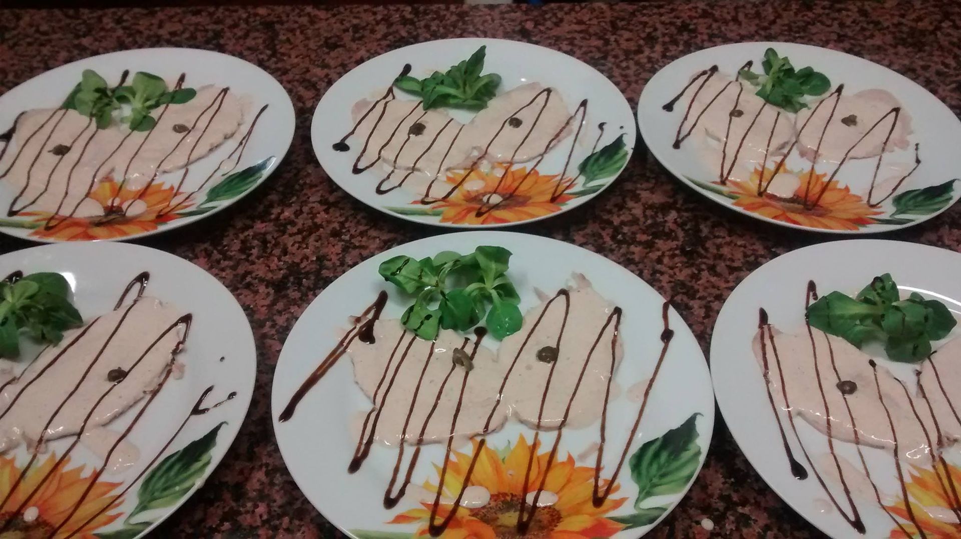 Sei piatti di cibo con salsa e verdure disposti su un piano di lavoro.