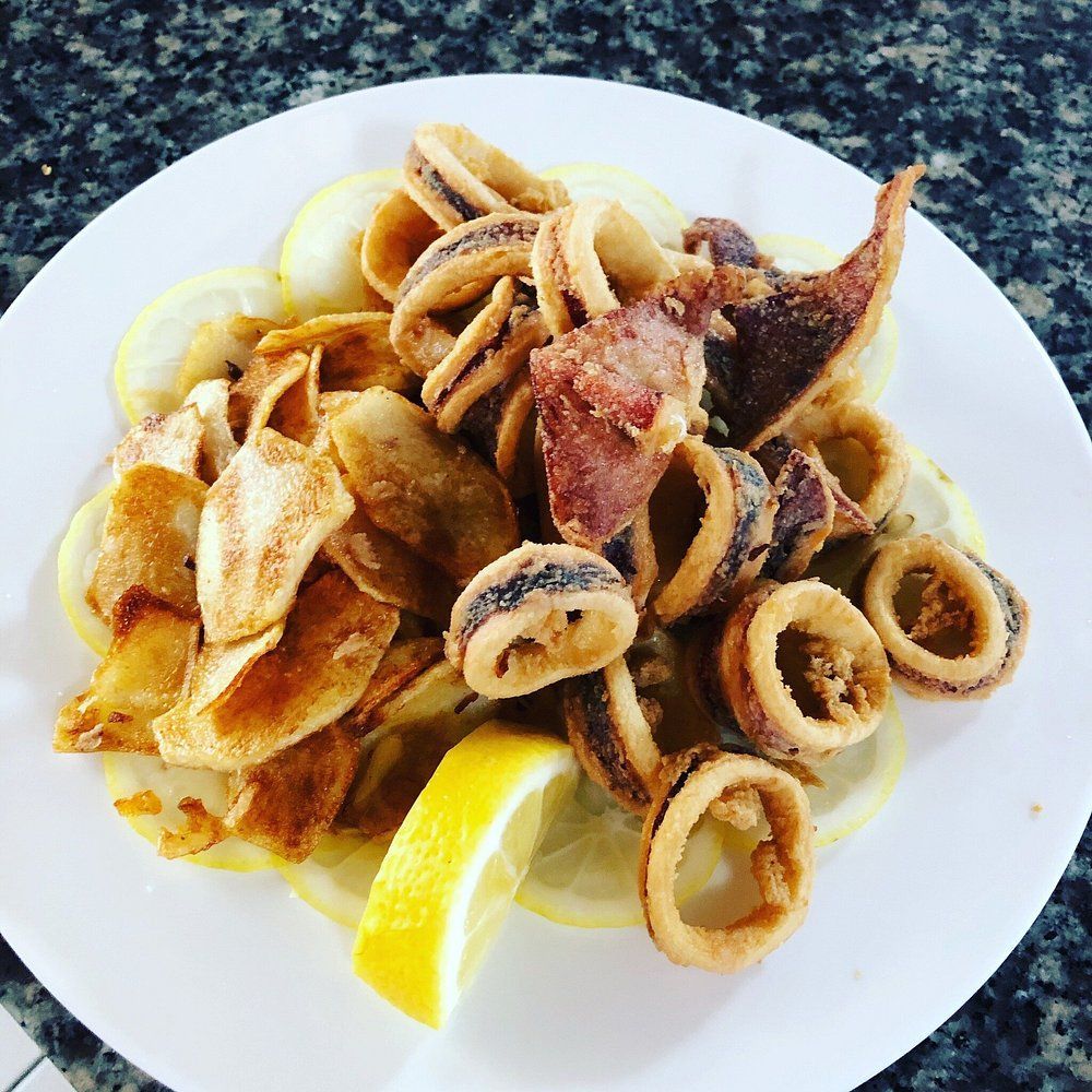 Piatto di calamari fritti con spicchi di limone su un piatto bianco