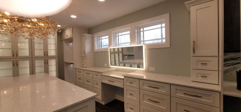 A large closet with lots of drawers and a large mirror.