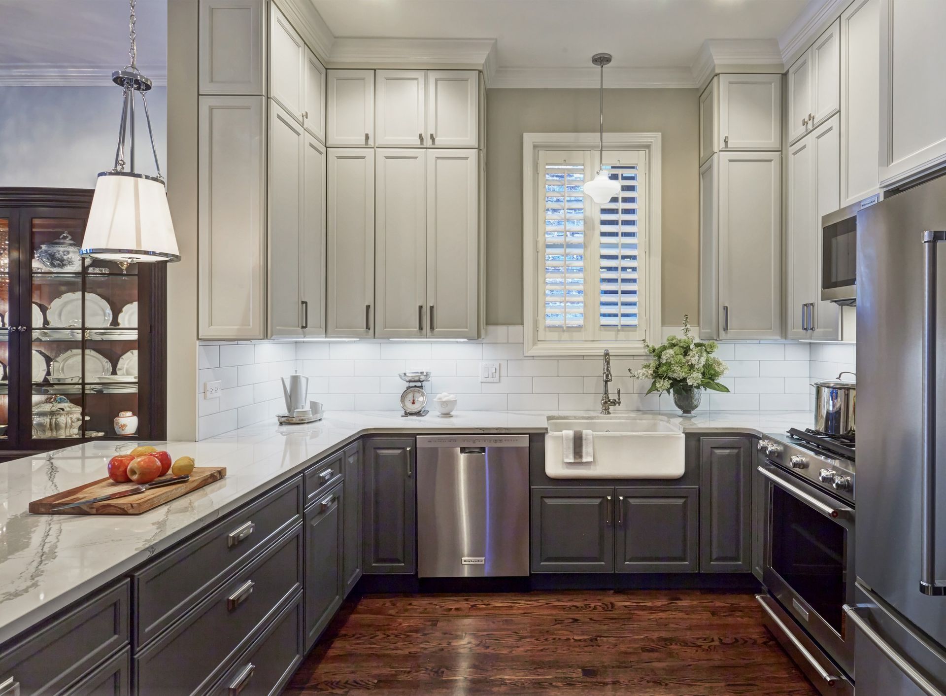 A kitchen with gray cabinets and stainless steel appliances