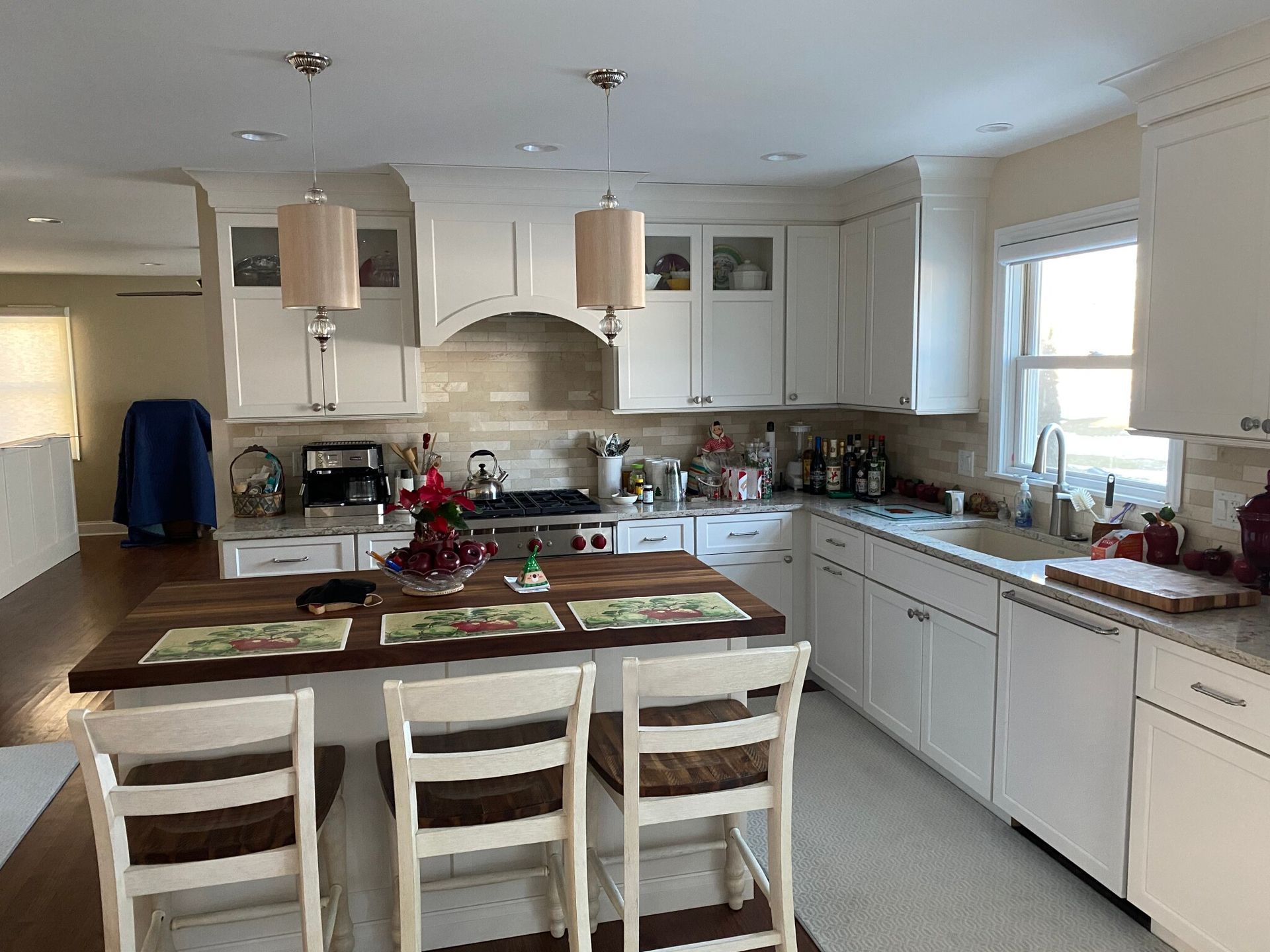 A kitchen with white cabinets and a wooden table and chairs