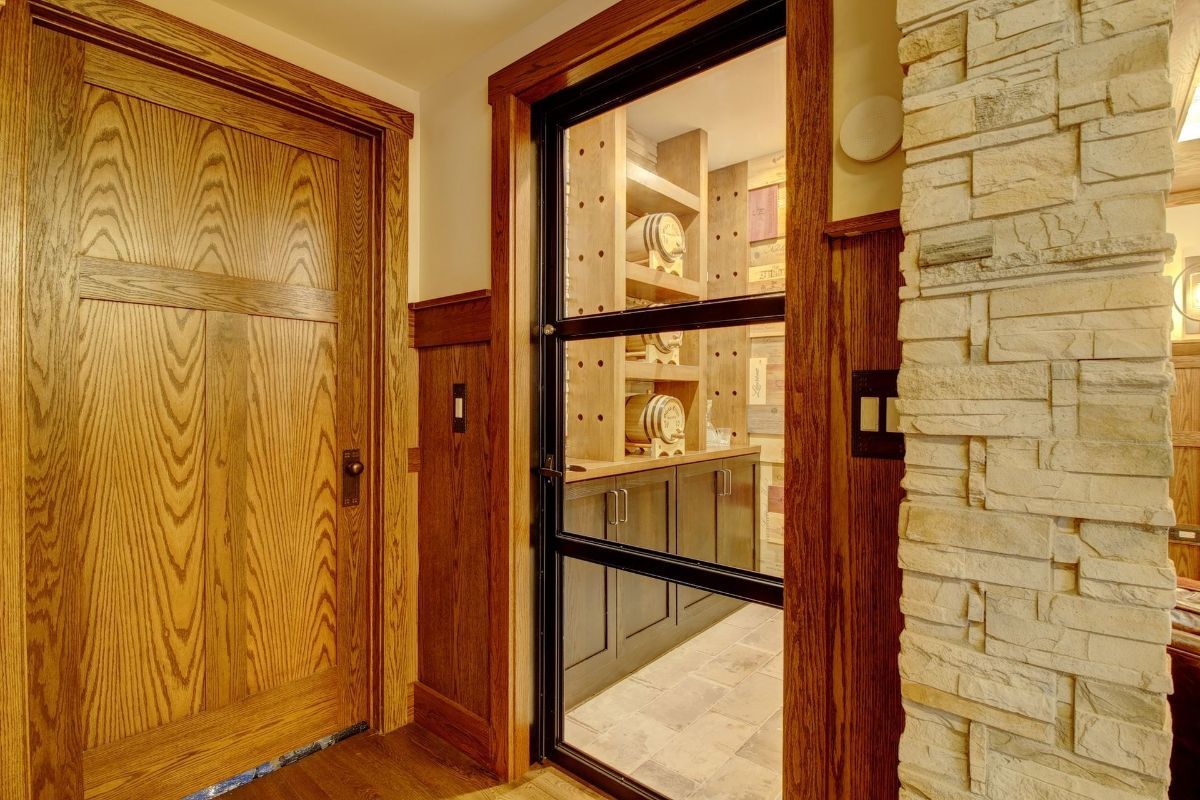 A hallway in a house with wooden doors and a brick wall.