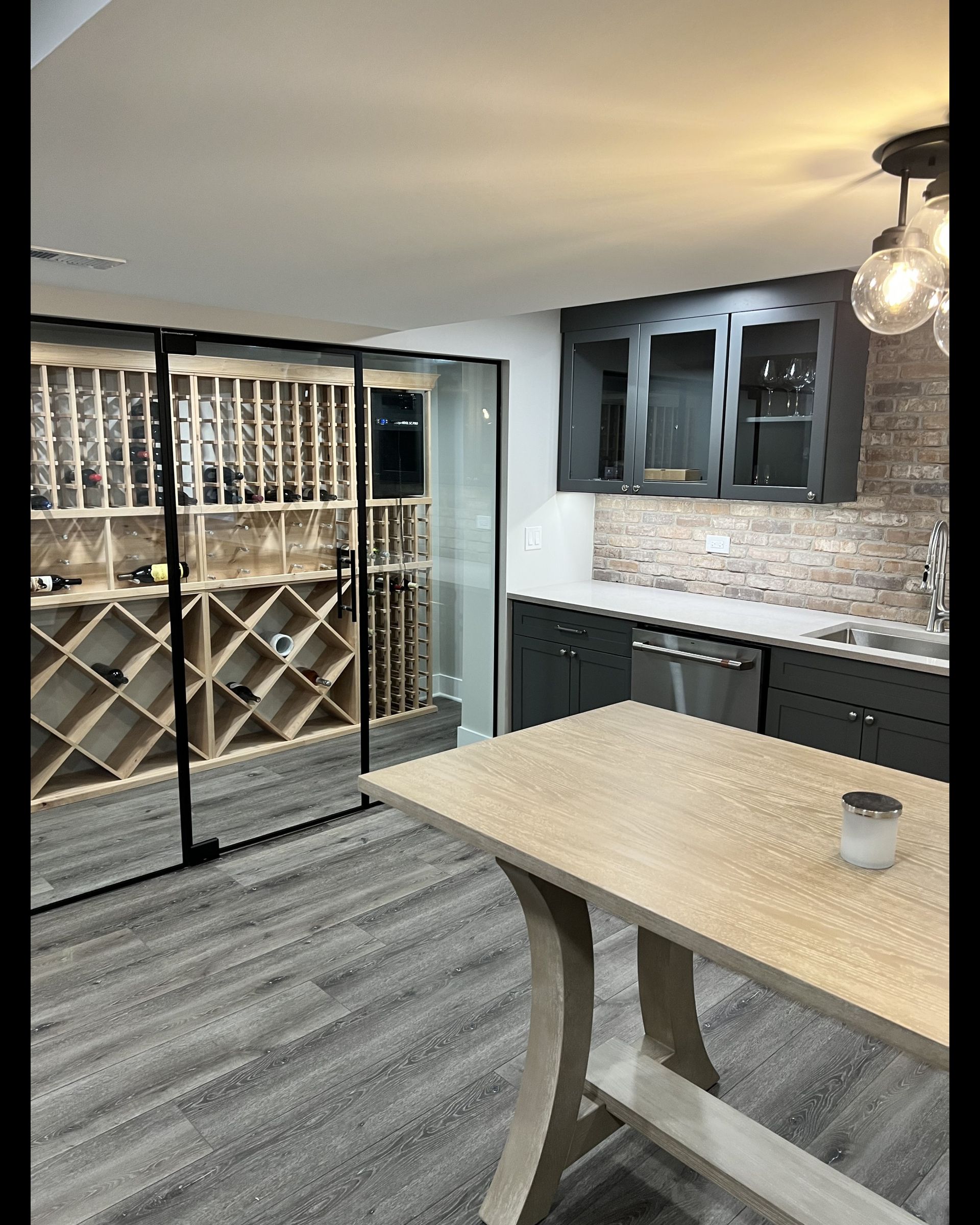 A kitchen with a table and a wine cellar.