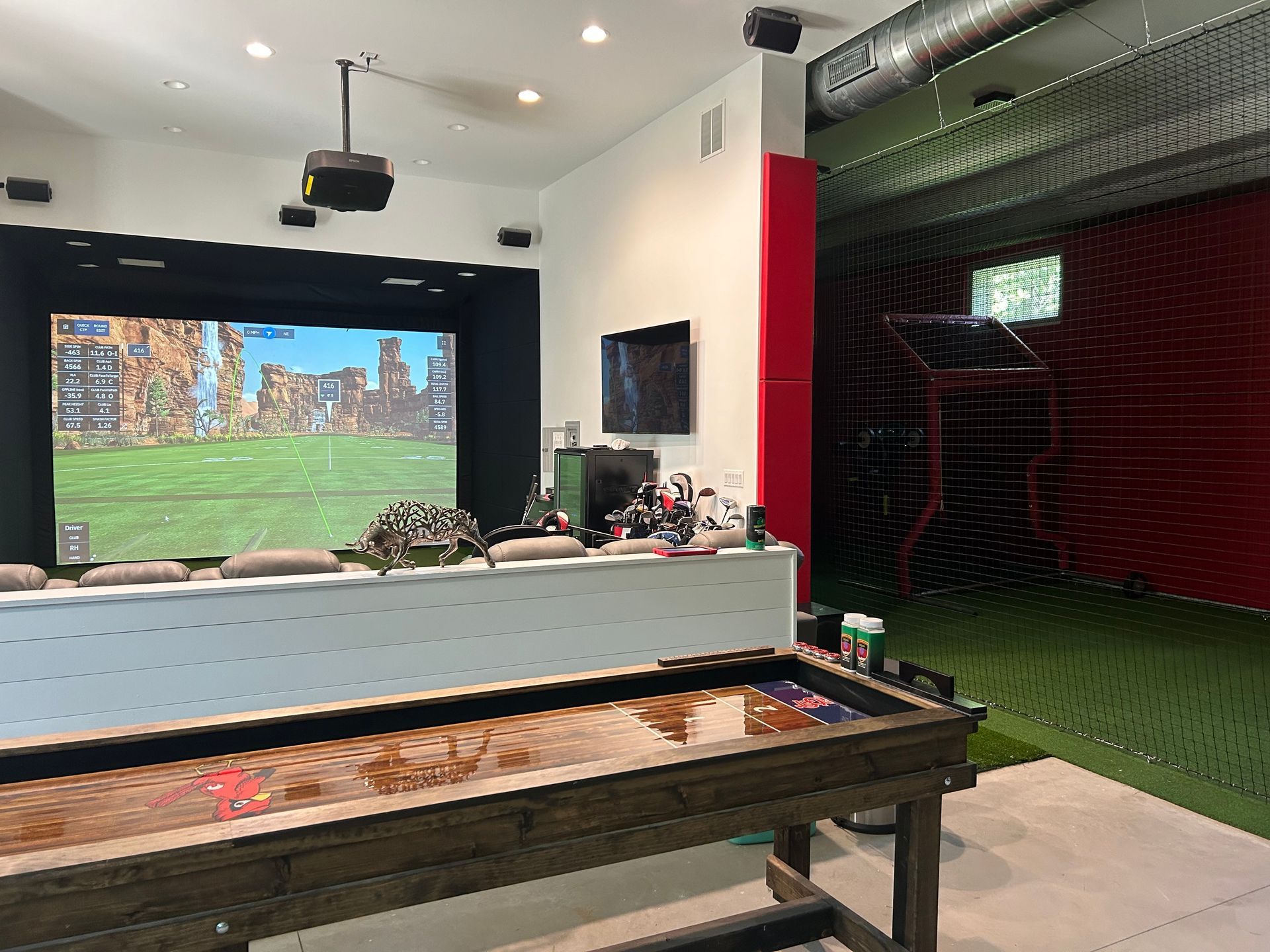 A room with a table and a large screen on the wall.