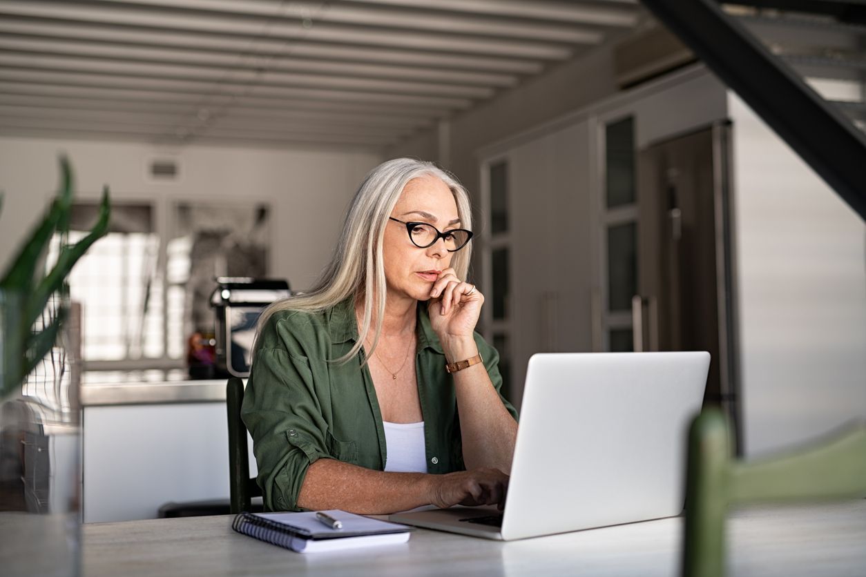 woman sitting at a laptop on the phone