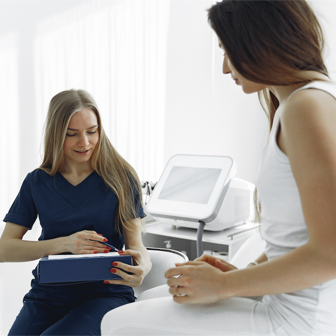 Two women in a clinic, a doctor and a patient.