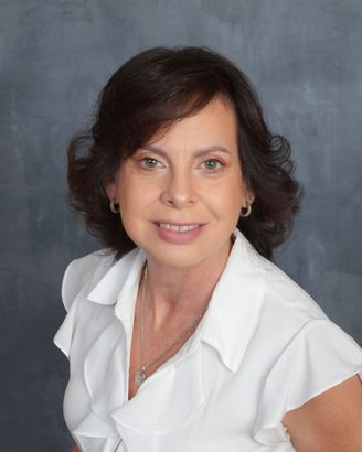 Ilka Nazario  in a white shirt is smiling for the camera