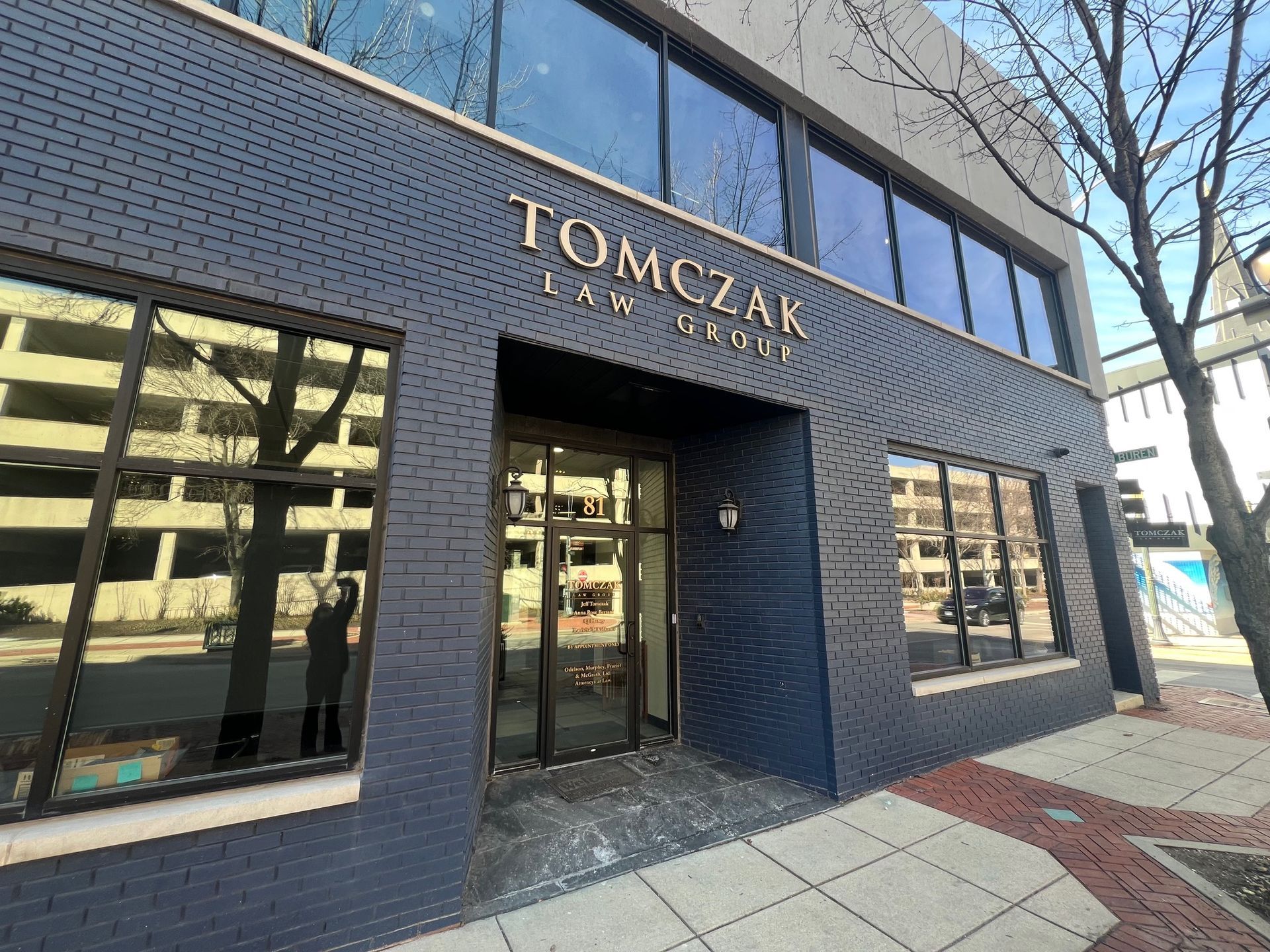 A tan two-story building with a white sign above the glass entrance doors reading A tan two-story building with a white sign above the glass entrance doors reading