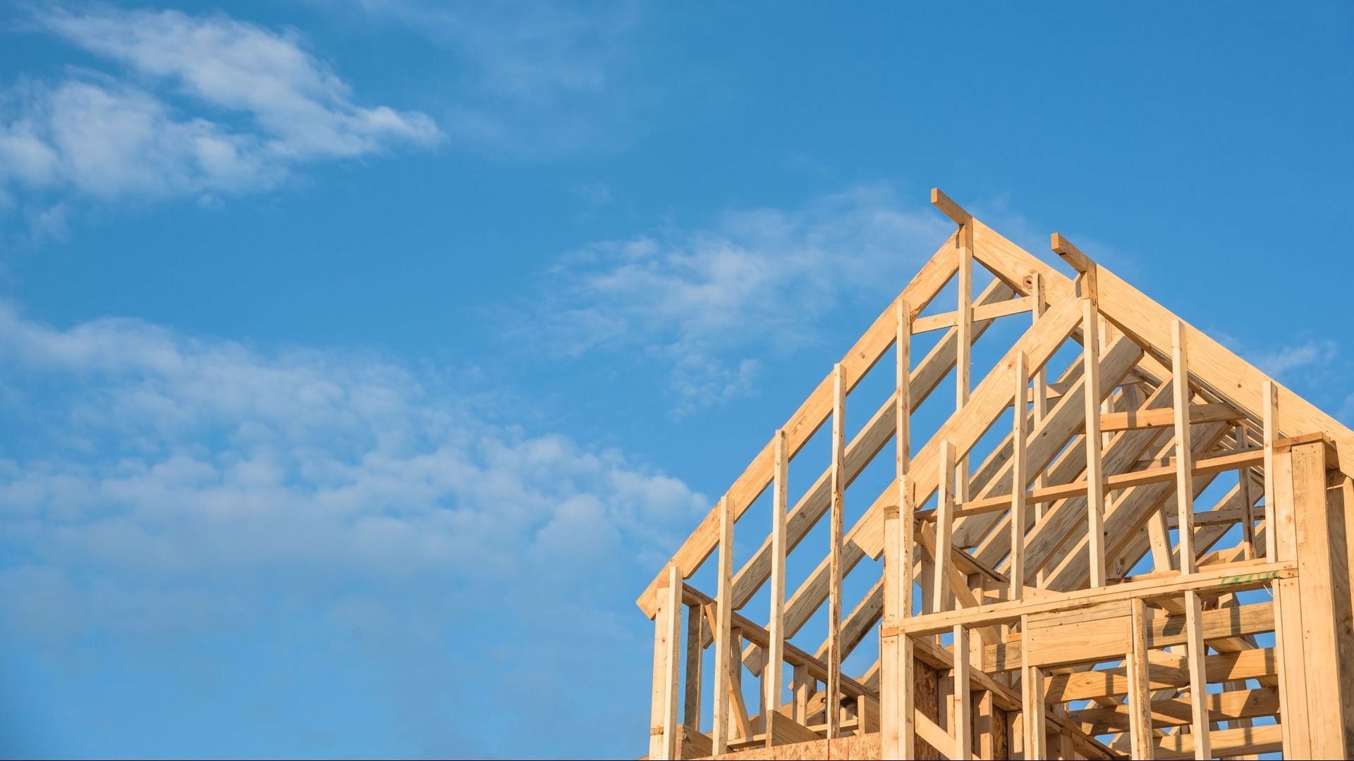 Une maison est en construction avec un ciel bleu en arrière-plan.