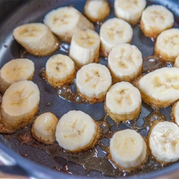 Sliced bananas being caramelized in a pan.