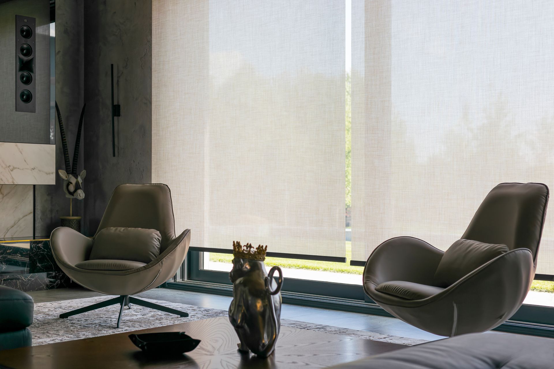 Interior solar shades covering two windows in a living room.