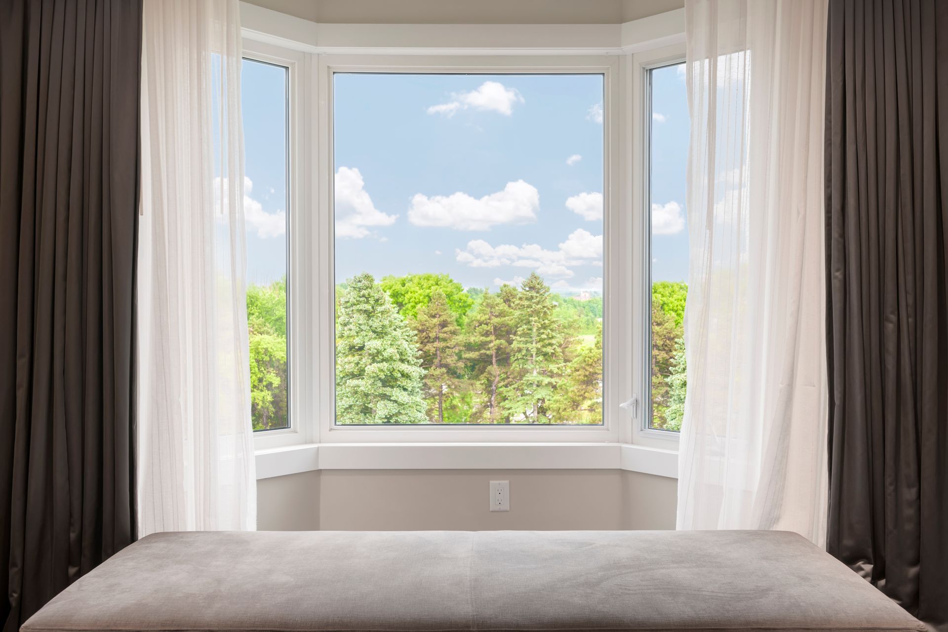 White and brown drapery covering a bay window.  
