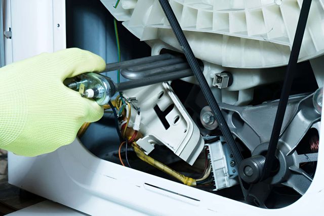 A Person Is Working On A Washing Machine — Tweed Coast Appliance Repairs In Clothiers Creek, NSW