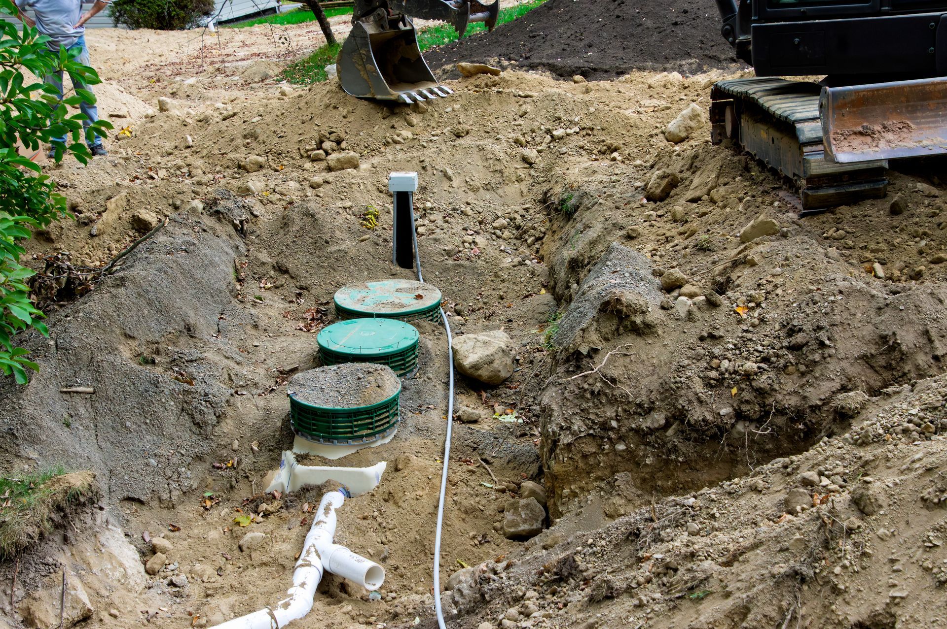 Partially buried treatment tank and UV disinfector with pipe connected.