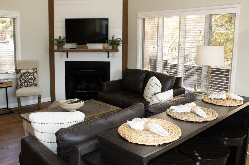 A living room with a couch , chair , table and television.
