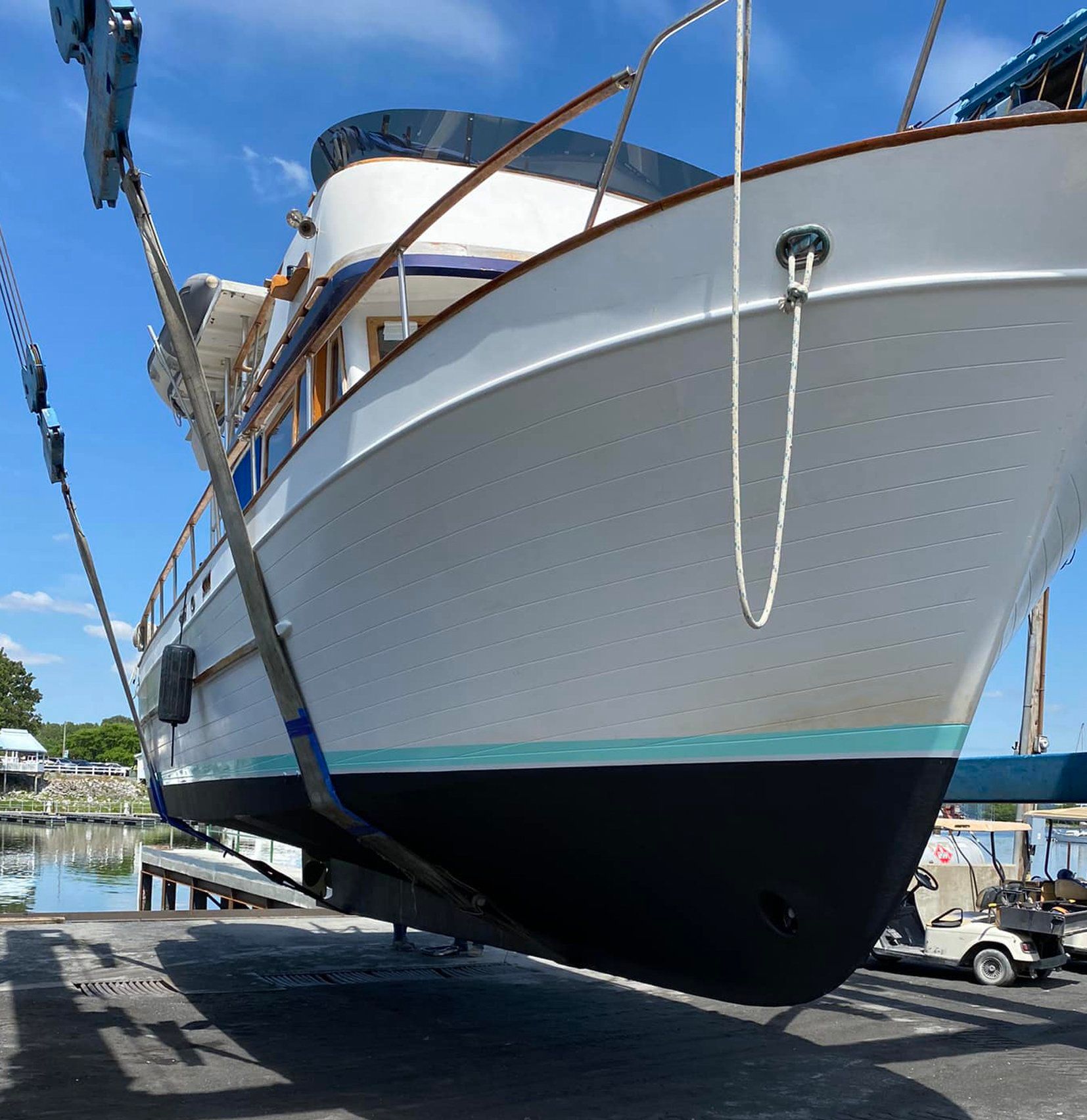 A large white and blue boat is tied to a dock