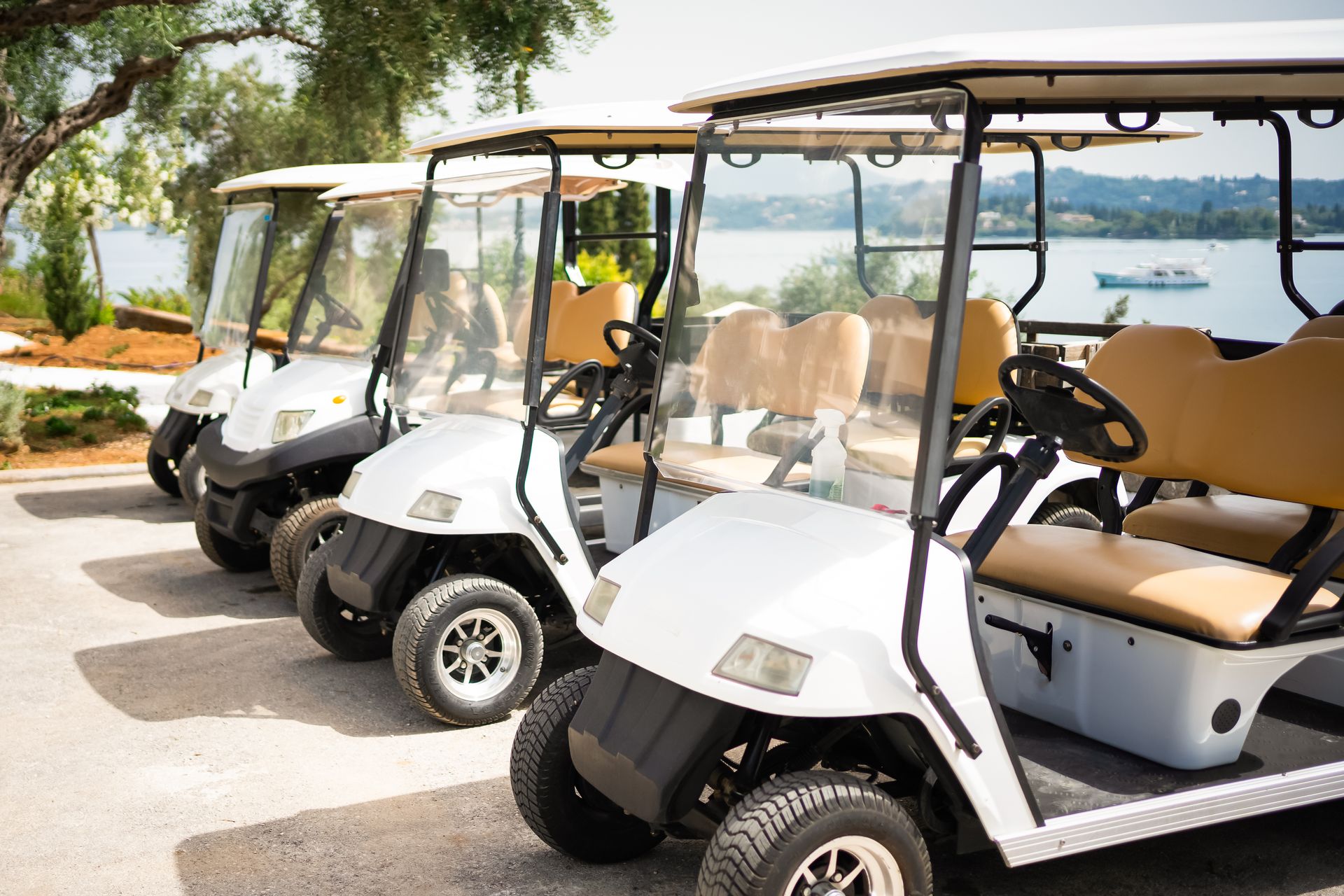 A row of golf carts parked next to each other in a parking lot.