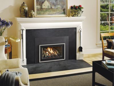 A living room with a fireplace and a painting on the mantle