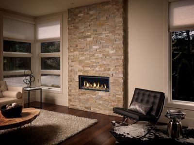 A living room with a fireplace and a brick wall.